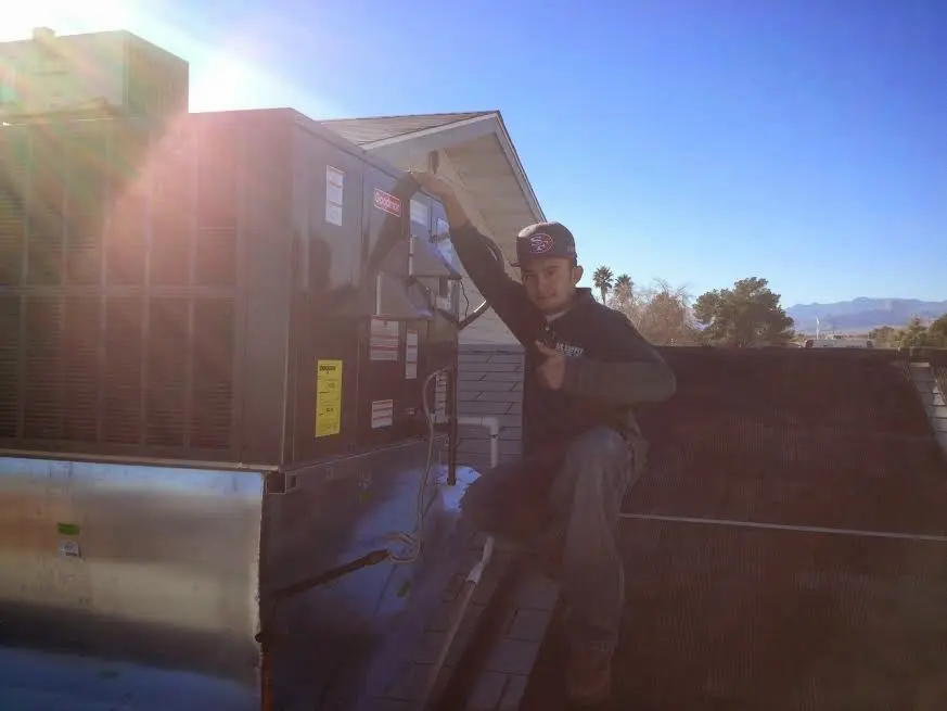 HVAC technician performing Air Duct Repair on a rooftop unit in Oroville East